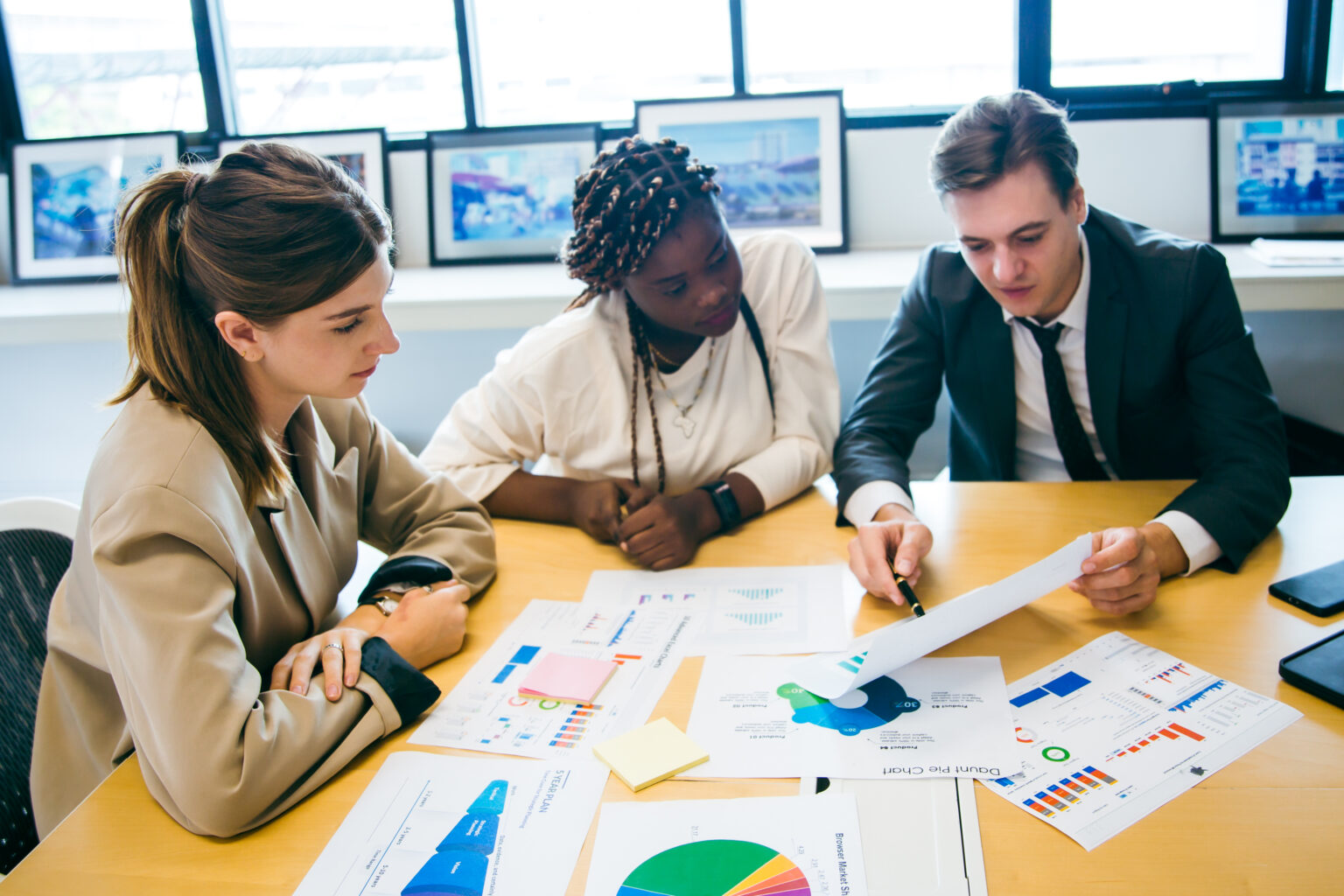 business team meeting with stats and review graphs of company target, goals or market research with data analysis. Above, table or paperwork report of growth, progress or startup performance analytics